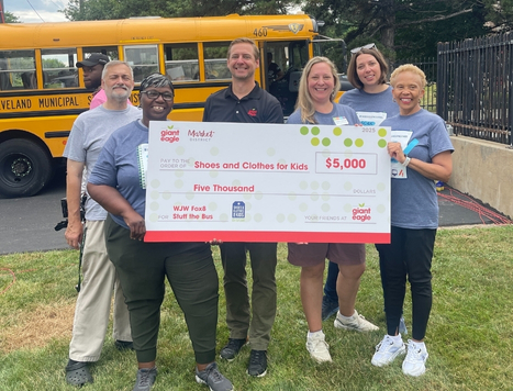 a group of people holding a large donation check at an event