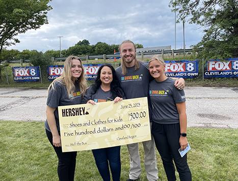 a group of people holding a large donation check at an event