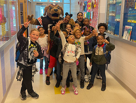 kids and mascot cheering in hallway