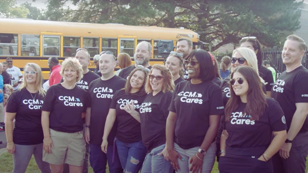 group of CrossCountry mortage employees wearing company tshirts standing in front of a bus