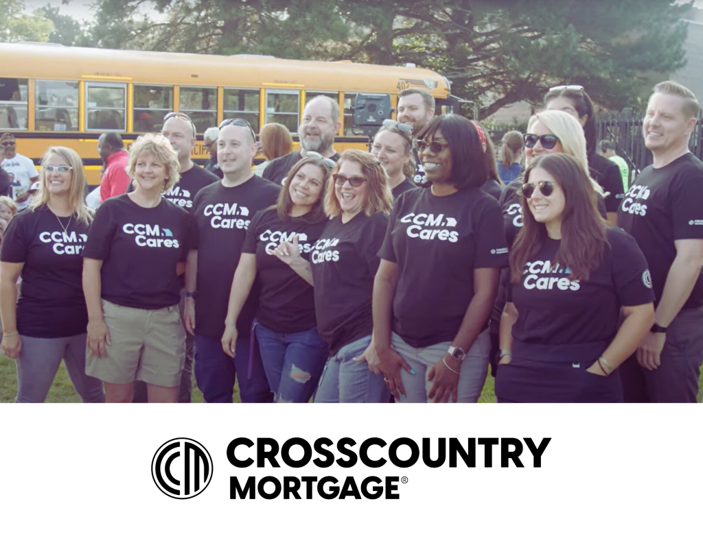 group of CrossCountry mortage employees wearing company tshirts standing in front of a bus