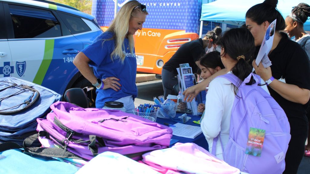 Family selecting new backpacks at the 3rd annual Back to School Bash